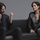 Keanu Reeves fist pumps in joy as Carrie Anne-Moss looks on, far less amused by it all.